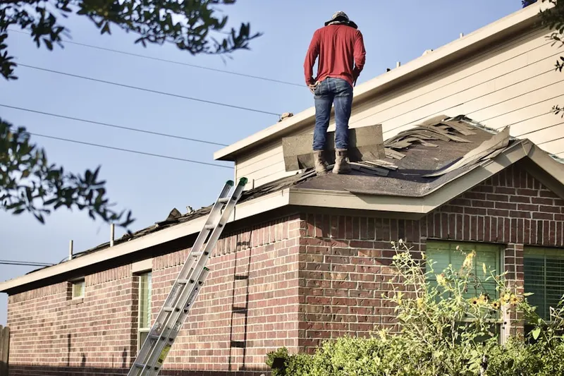 Professional roofer working on a residential roof in Wooded Hills